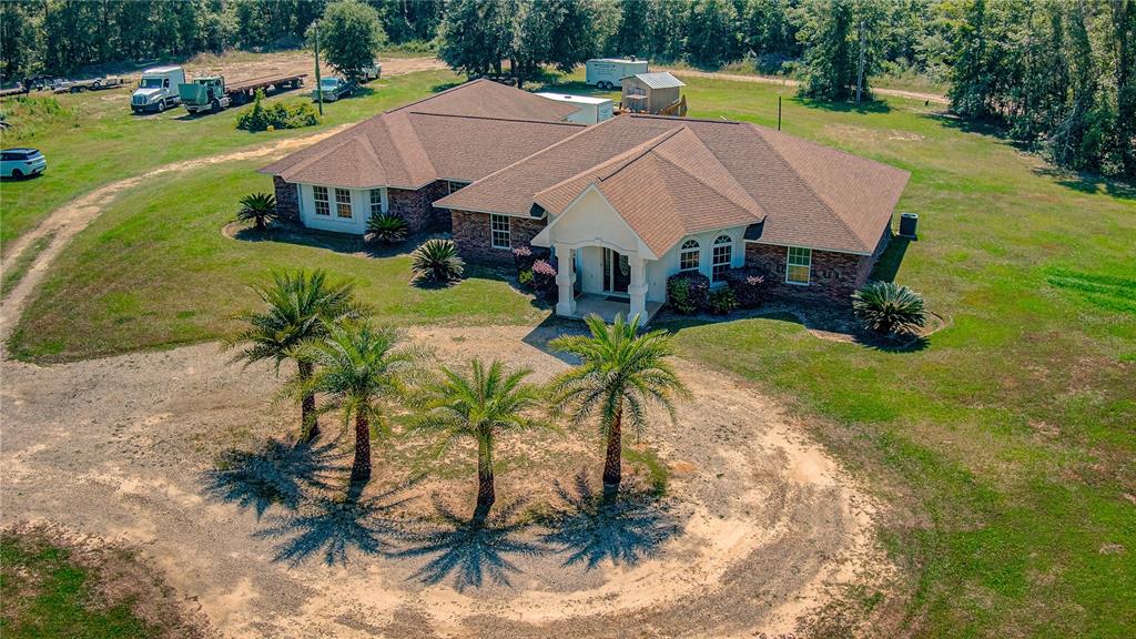 an aerial view of a house with swimming pool and garden