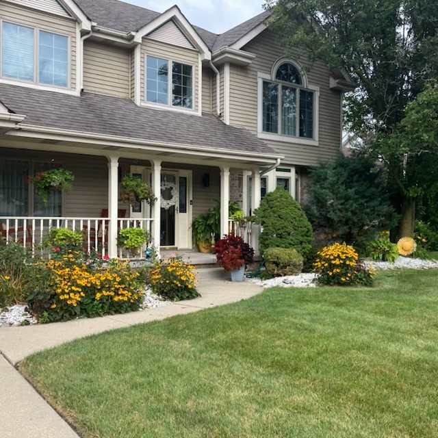 a front view of a house with a garden and plants