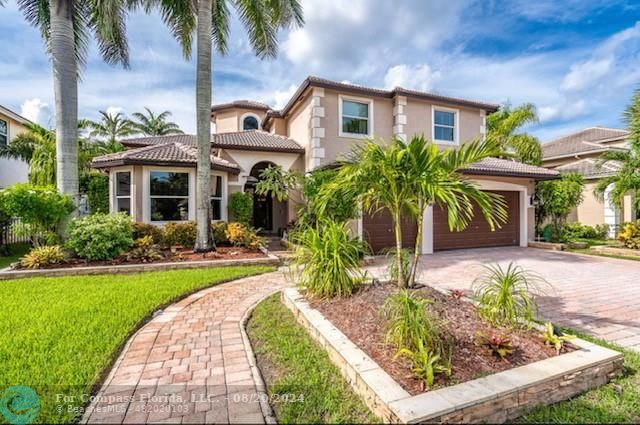 a front view of a house with a yard and potted plants