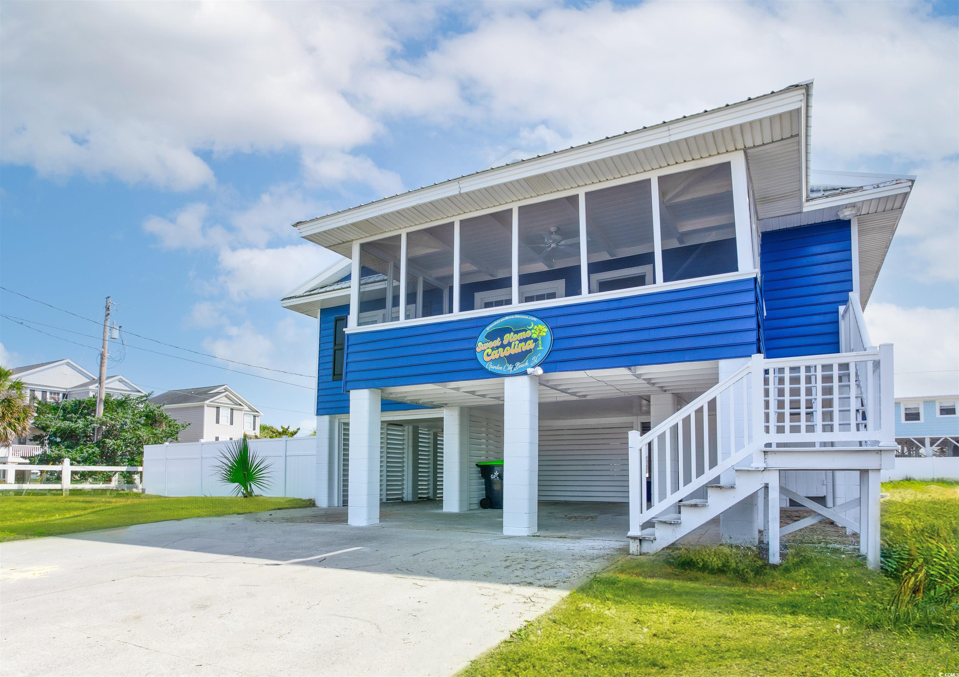 View of front of house with a carport and a sunroo