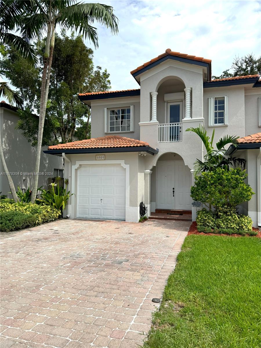 a front view of a house with a garden and palm trees