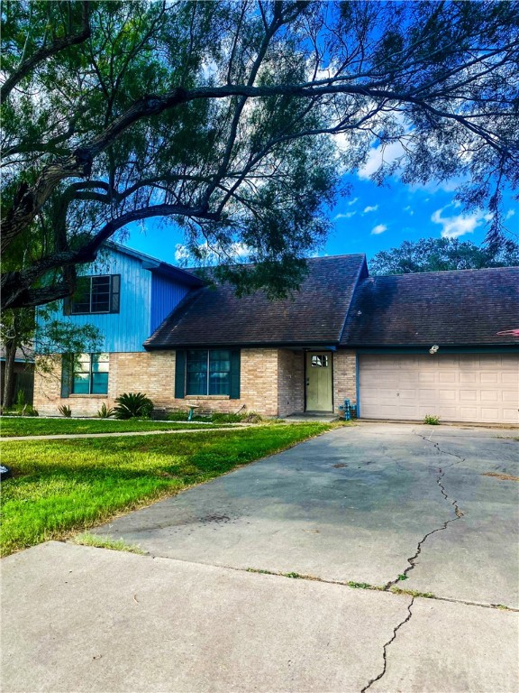 a front view of a house with a garden and tree