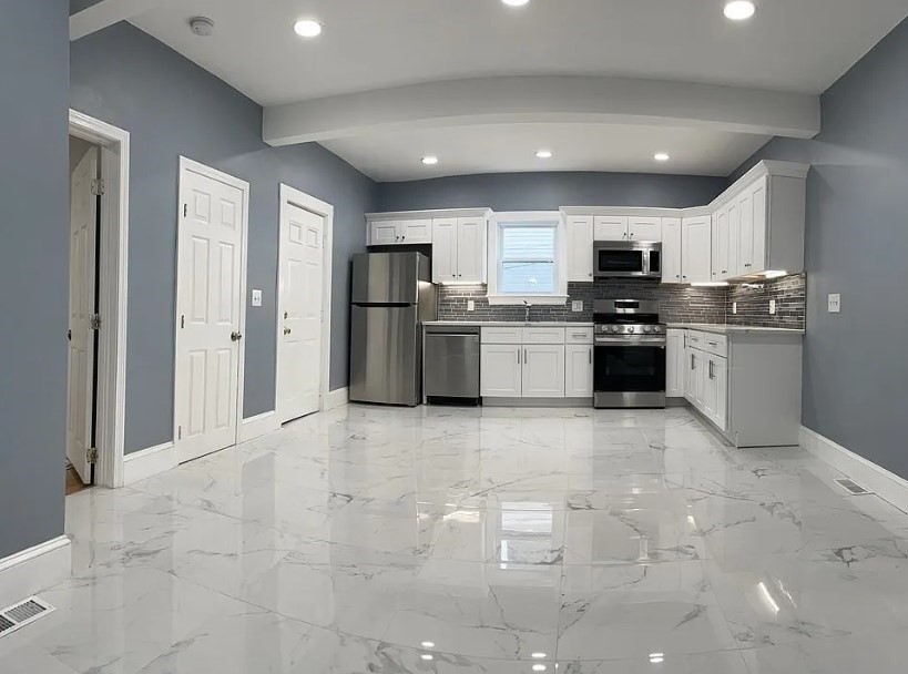 a kitchen with stainless steel appliances a refrigerator stove top oven and sink