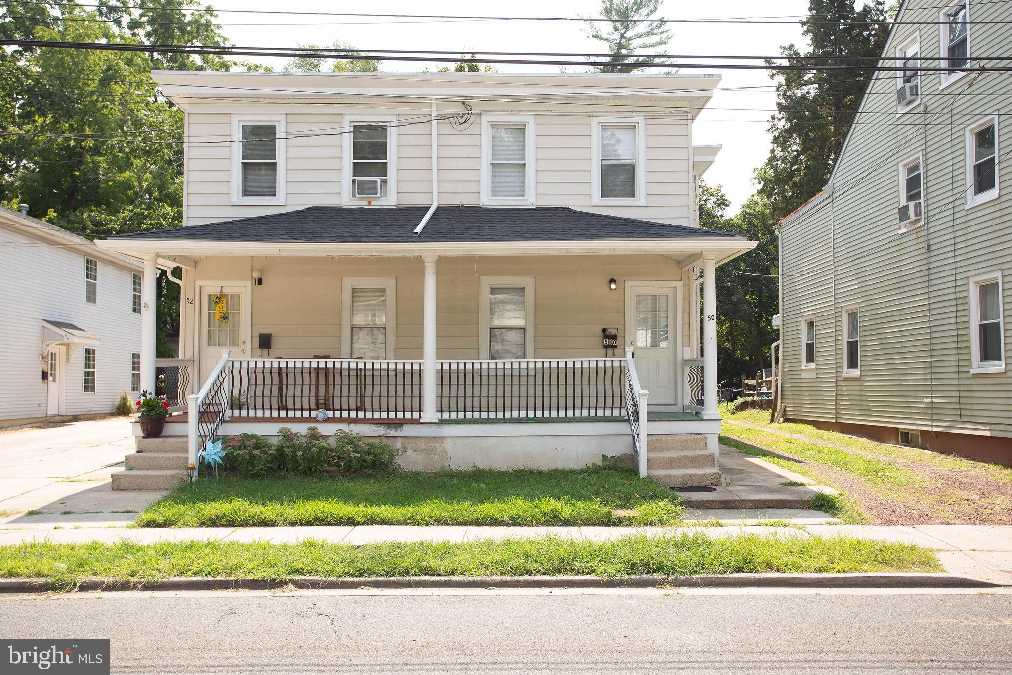 a view of a white house with a yard and large windows