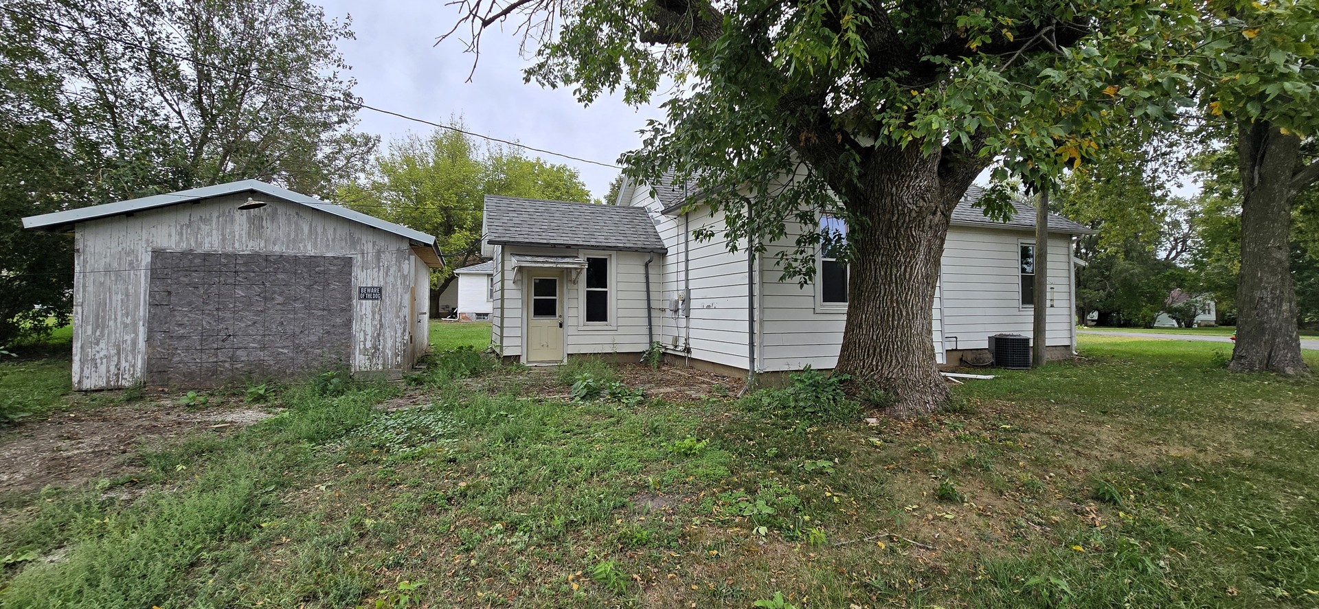 a view of a house with a yard and large trees