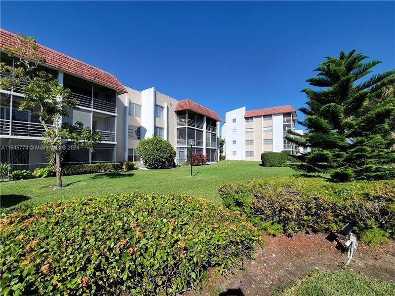 a view of a house with a big yard plants and large trees