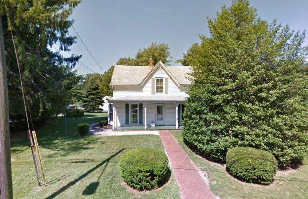 View of front of property featuring a porch and a front yard