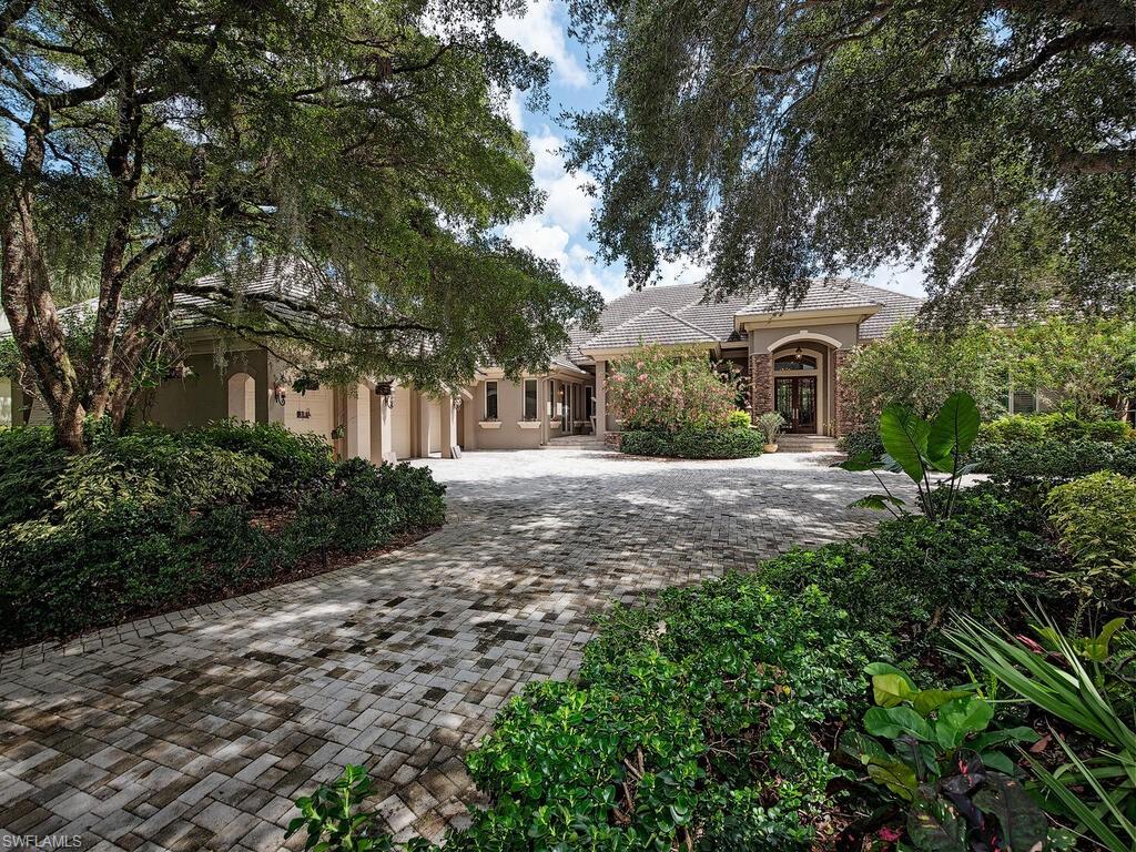 a front view of a house with a yard and trees