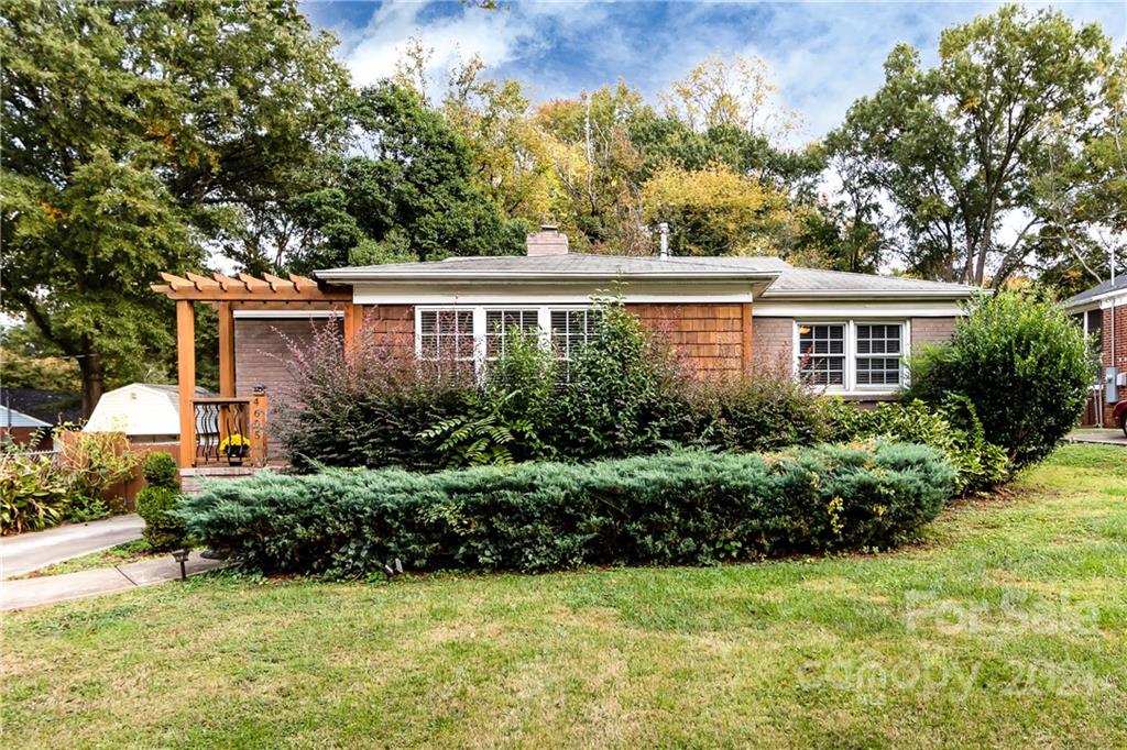 a front view of a house with a yard and trees