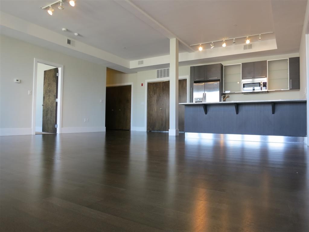 a view of a living room with kitchen countertops and wooden floor