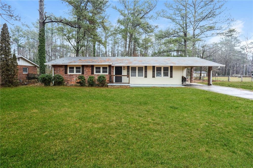 a view of a house next to a big yard and large trees