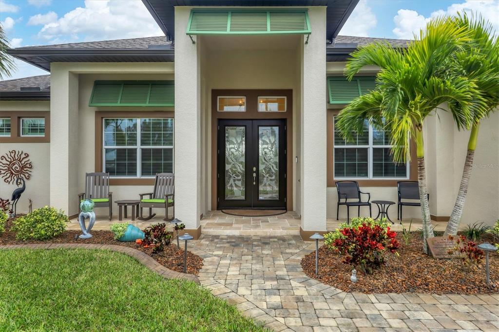 a front view of a house with outdoor seating and a garden