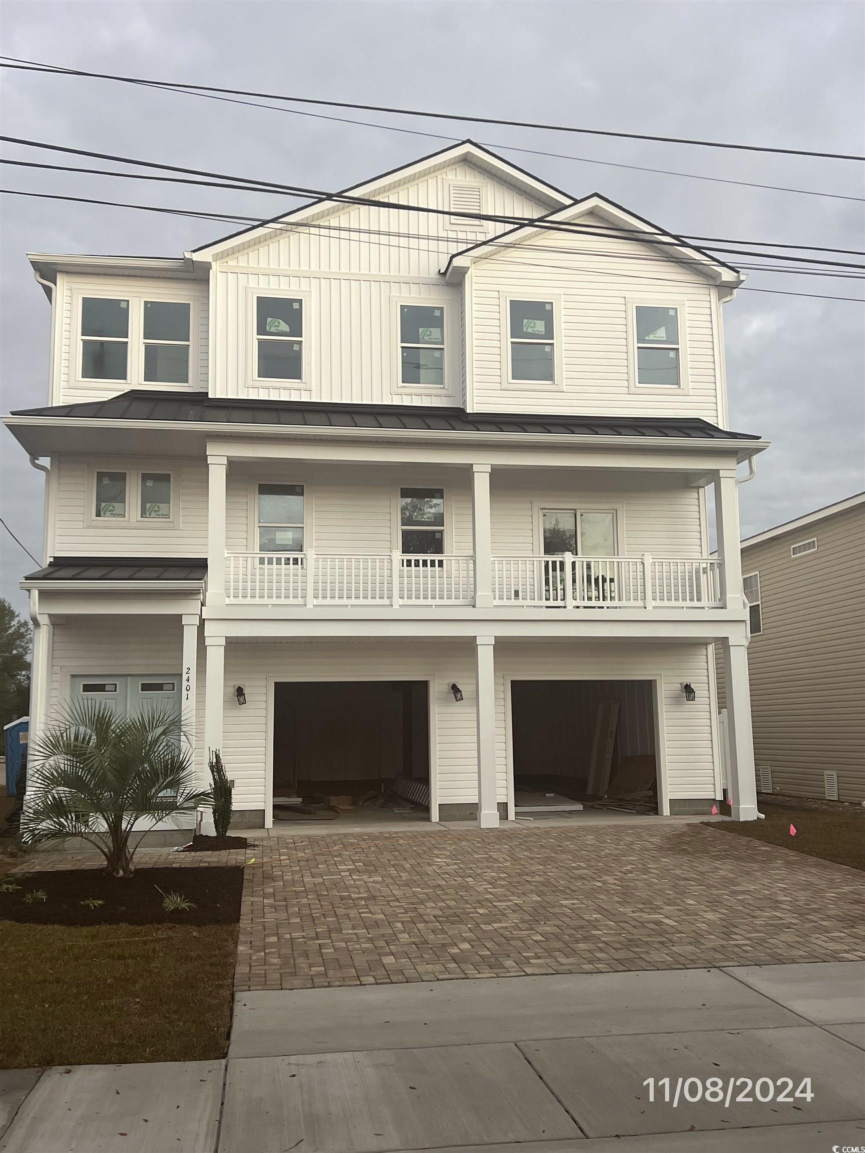 View of front of home featuring a garage and a bal