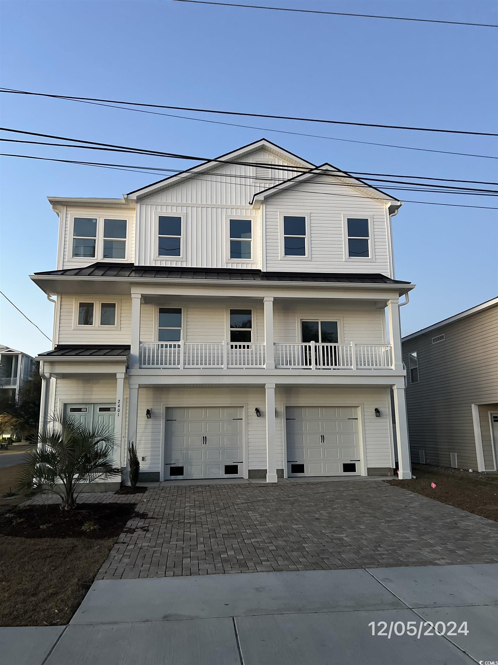 View of front of home featuring a balcony and a ga