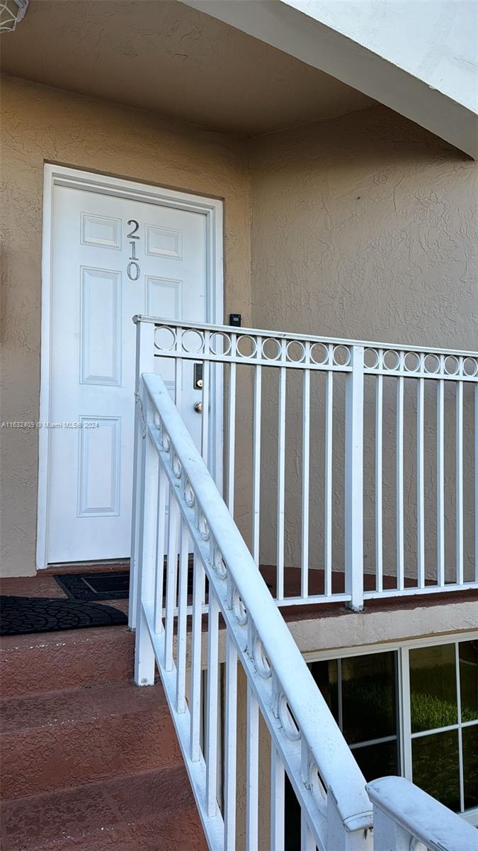 a view of staircase with railing and white walls