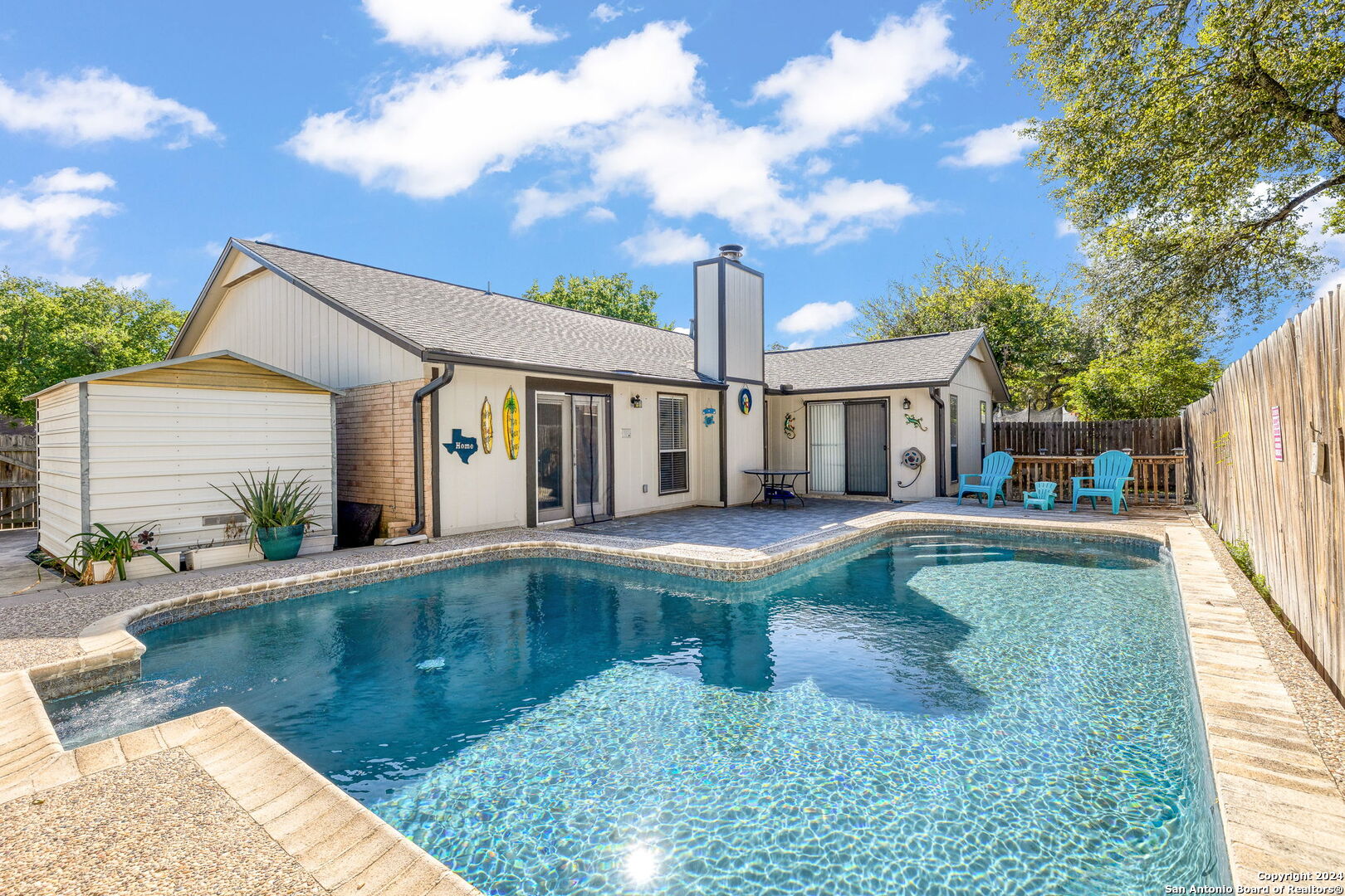 a view of a white house with a swimming pool and a yard