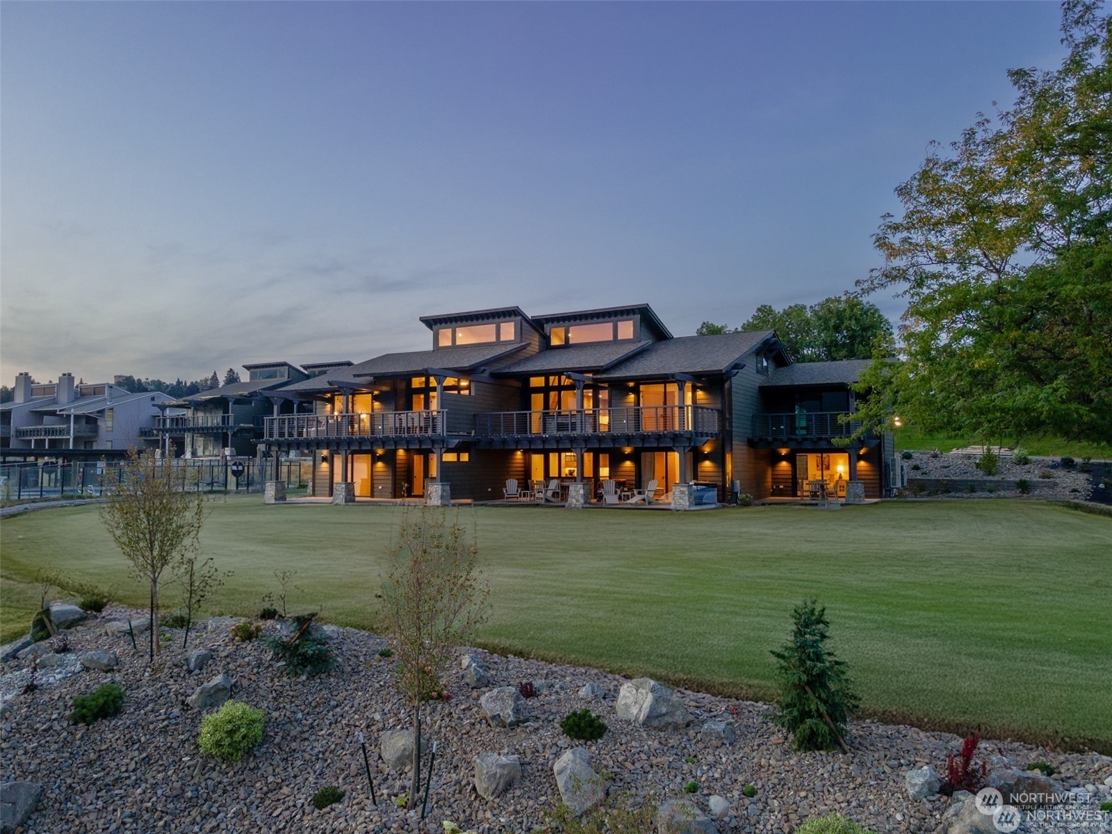 a view of a lake with a big yard and large trees