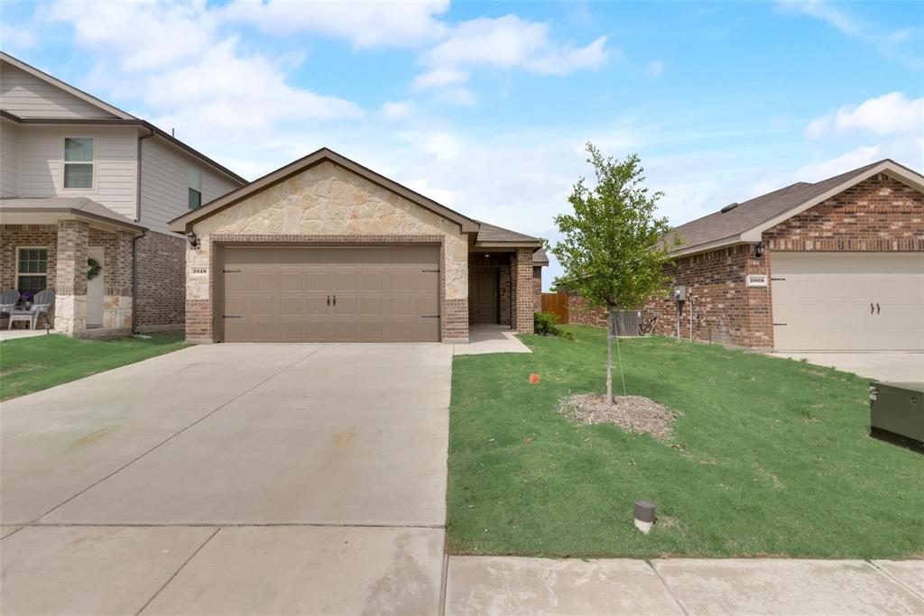 a view of a house with a yard and a garage