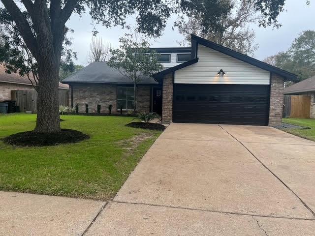 a front view of house with yard and trees in the background