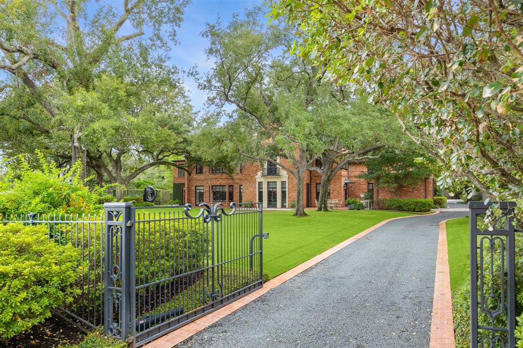 a view of a house with a big yard and large trees