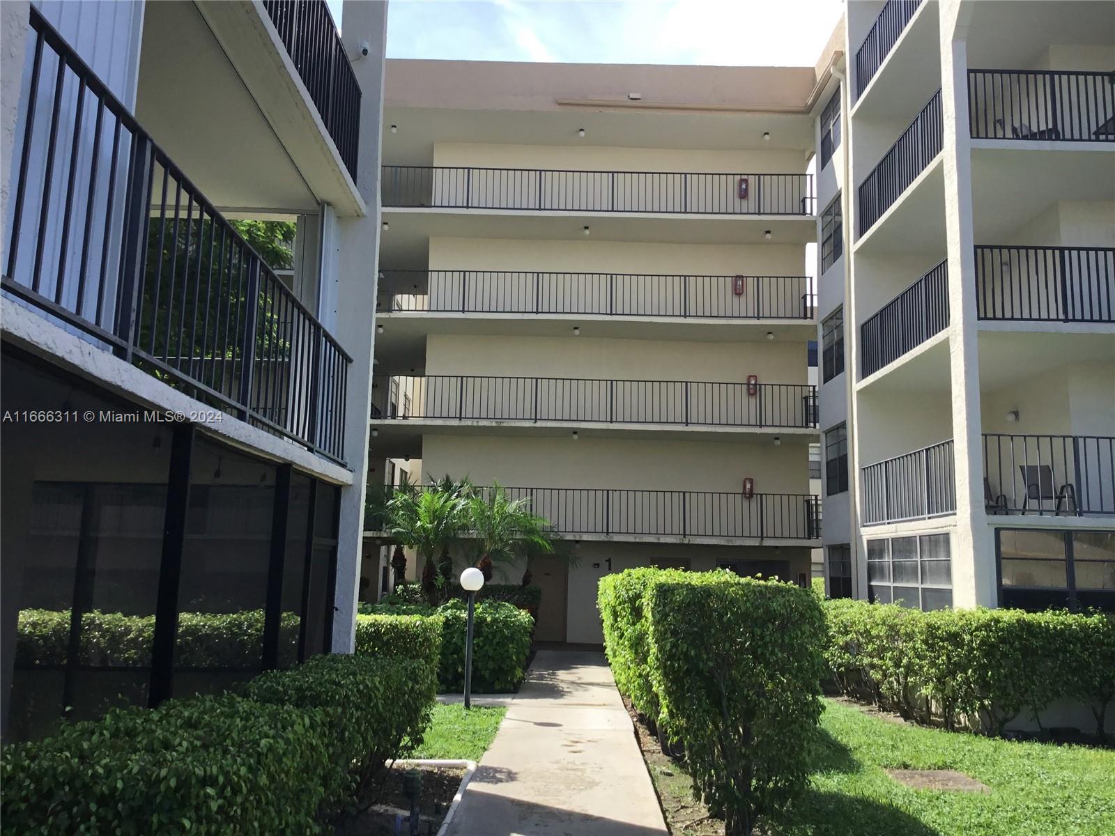 a front view of a building with a garden