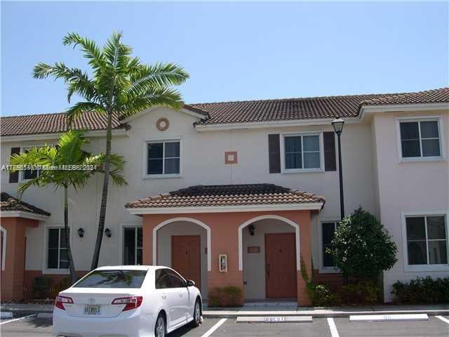 a front view of a house with plants