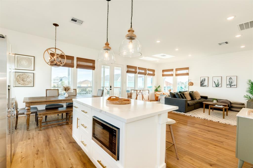 a open kitchen with stainless steel appliances granite countertop a stove and a wooden floors