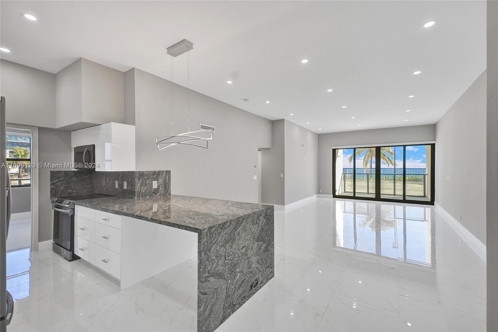 a large kitchen with stainless steel appliances granite countertop a sink and a large window