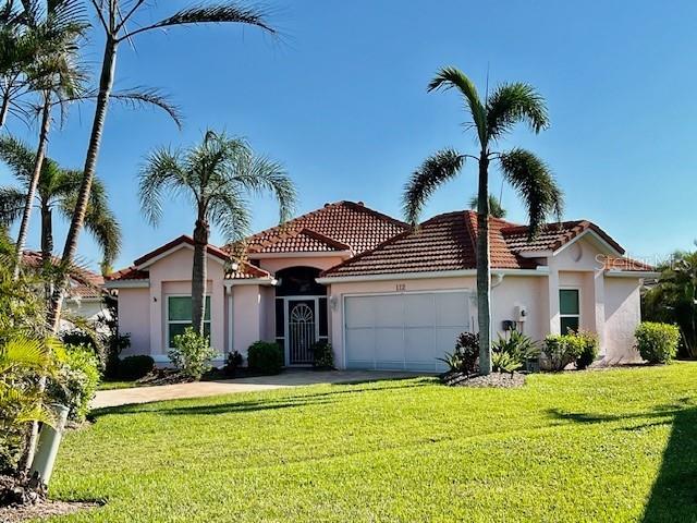 a front view of a house with a garden and palm trees