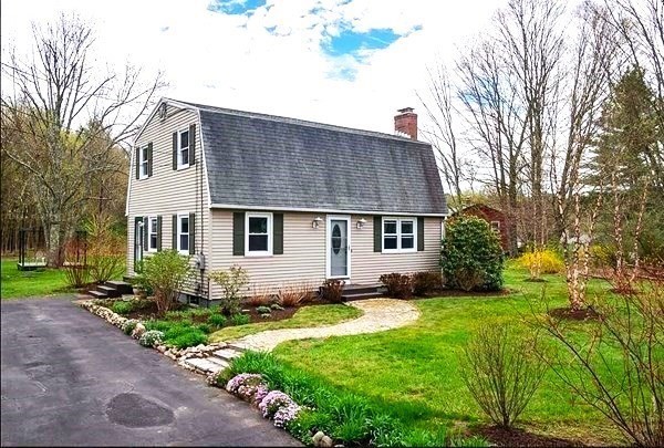 a front view of house with yard and green space