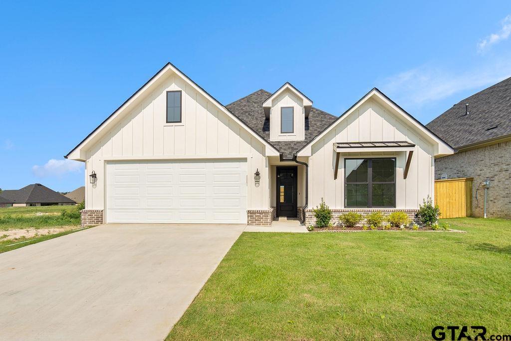 a front view of a house with yard outdoor seating and garage