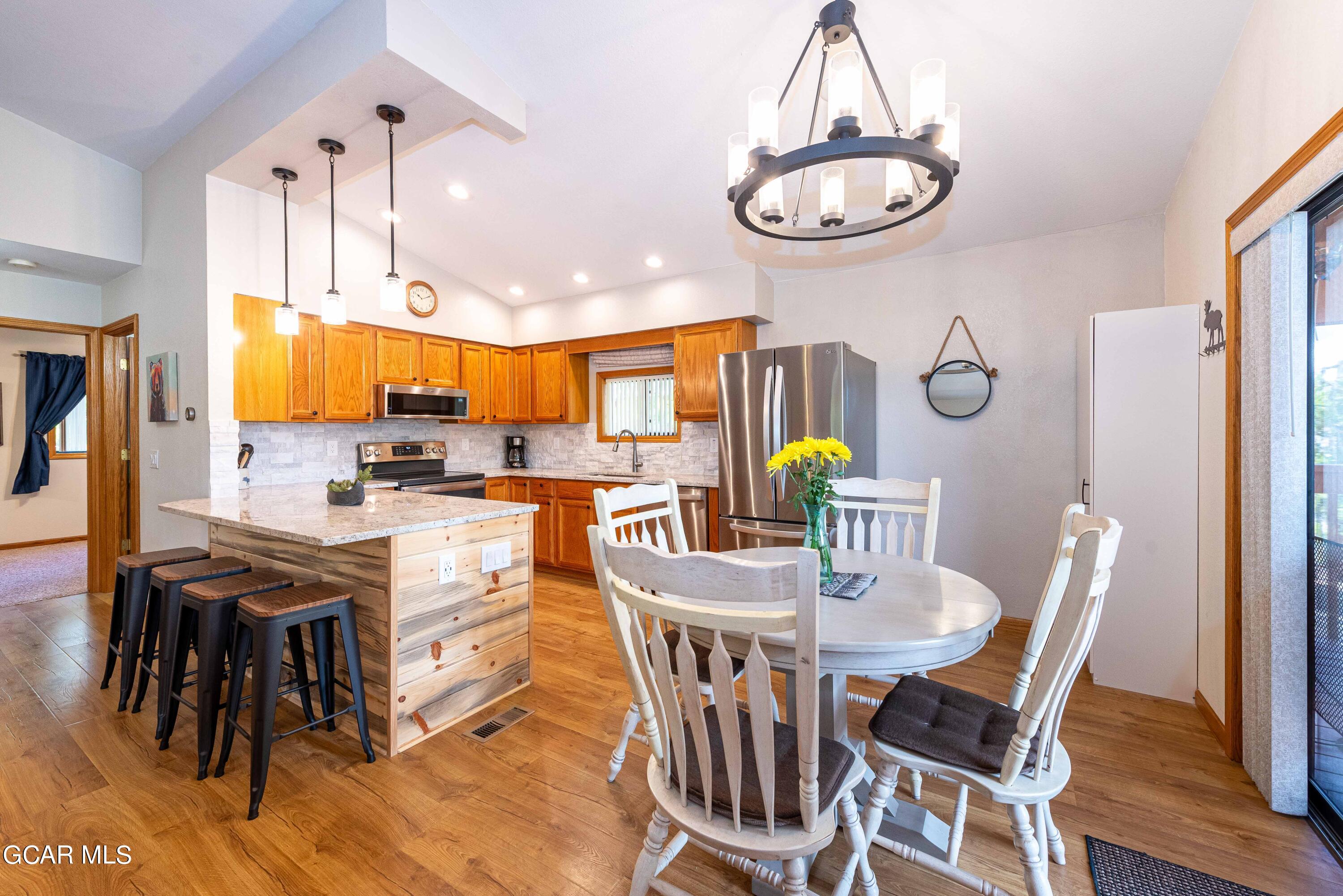 a view of a dining room with furniture a chandelier and wooden floor