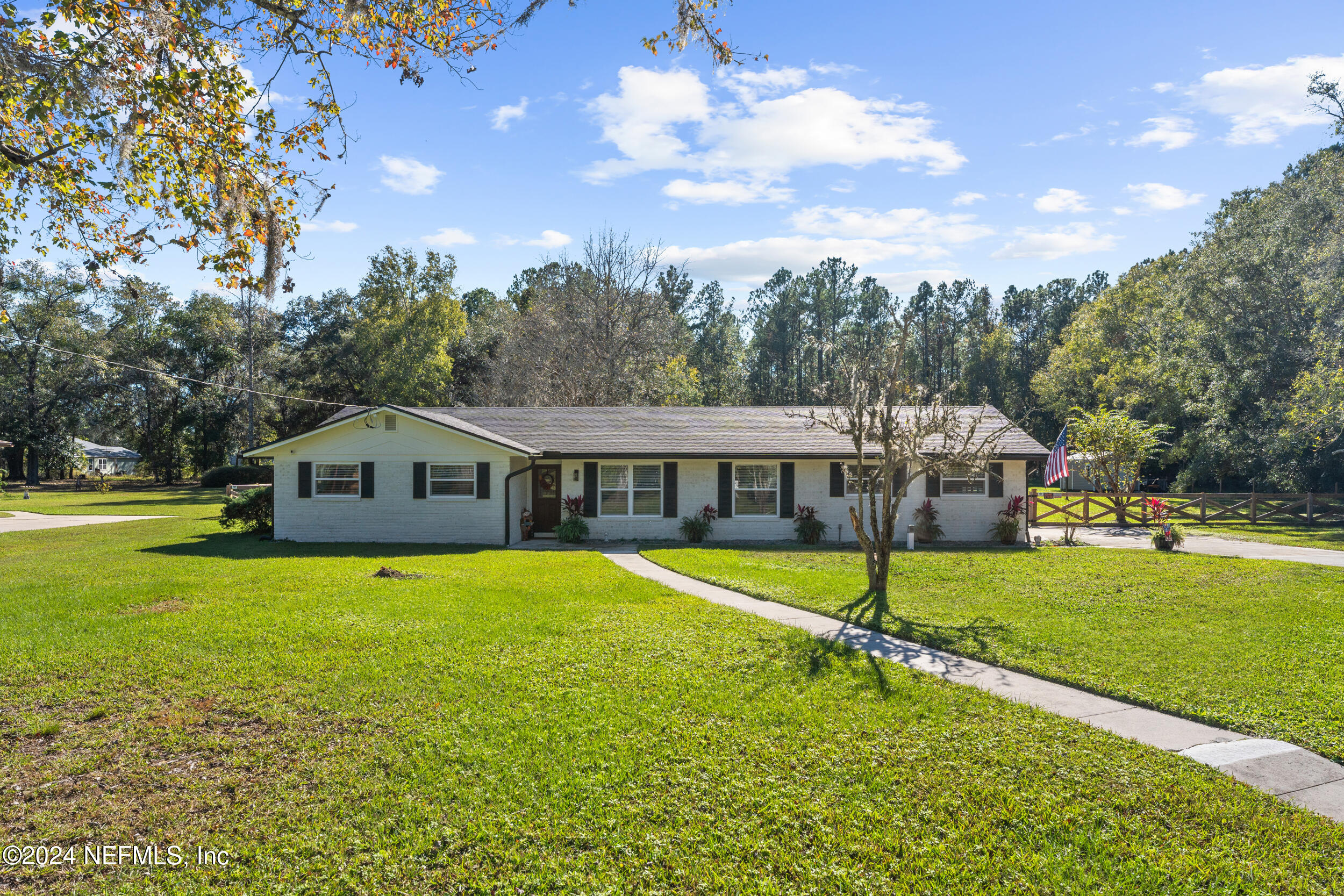 a front view of a house with a yard and trees