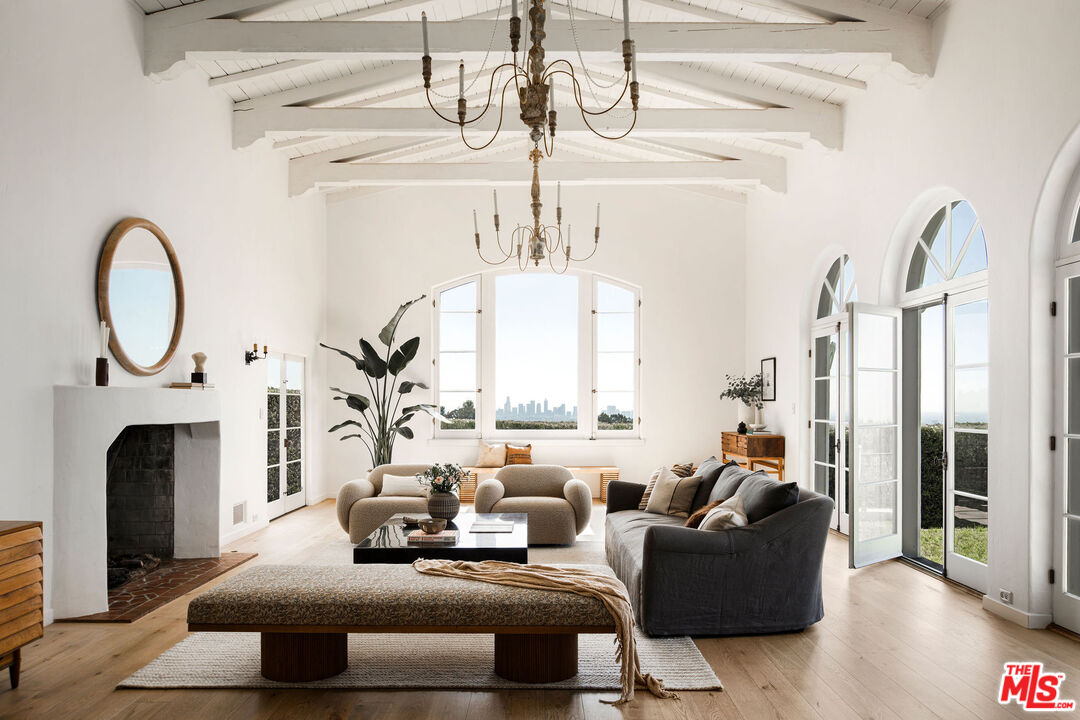 a living room with fireplace furniture and a large window