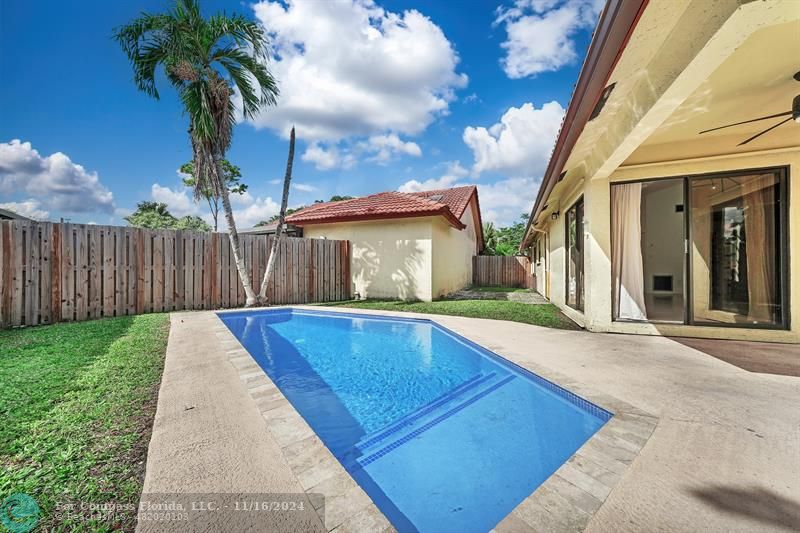 a view of a backyard with table and chairs and wooden fence