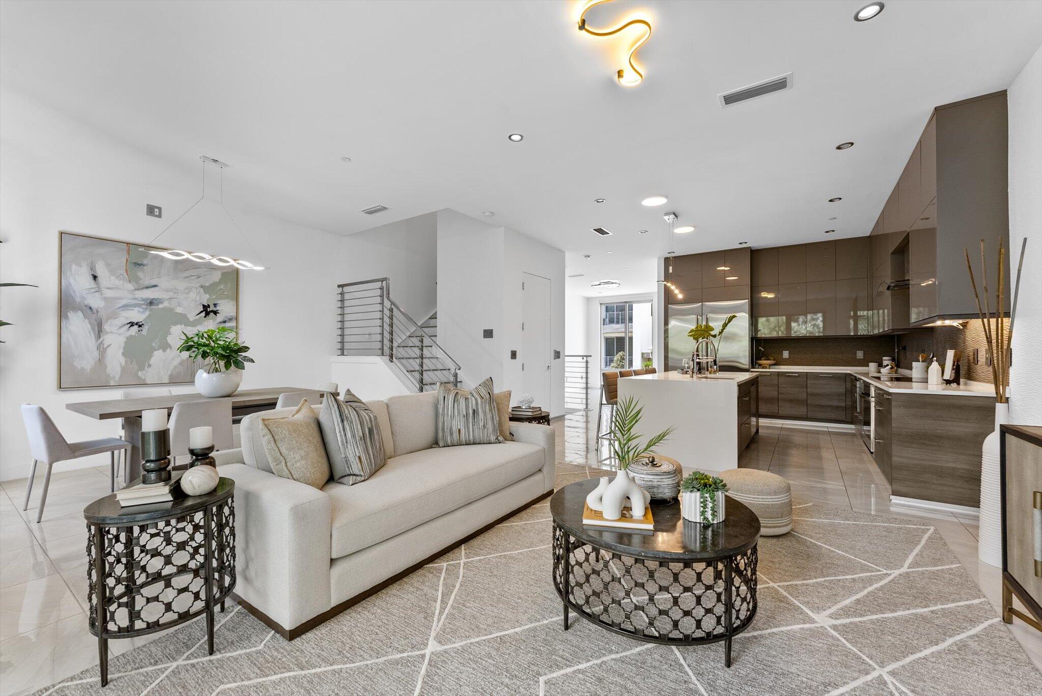 a living room with furniture and a dining table with kitchen view