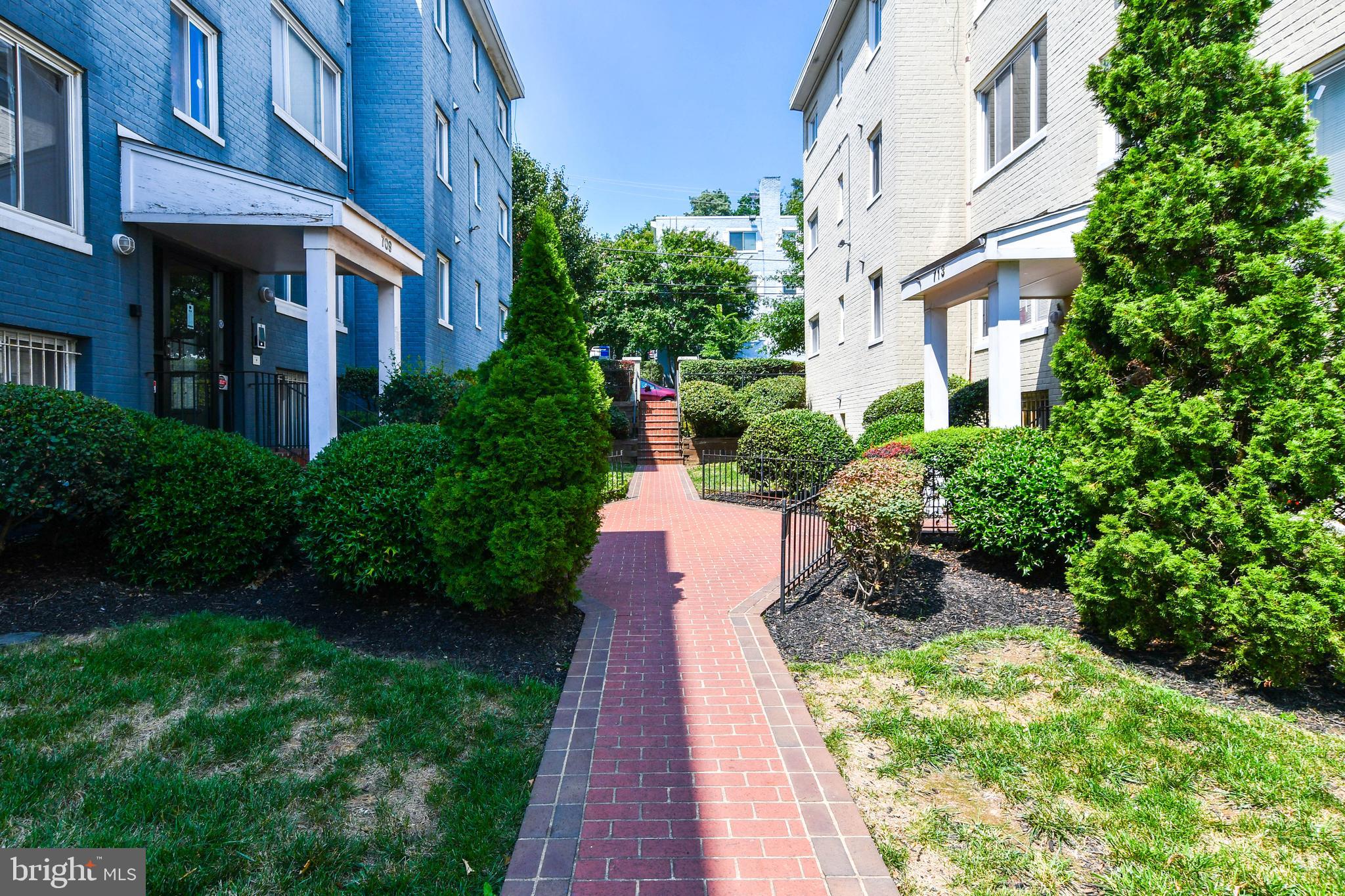 a front view of a multi story residential apartment building with yard