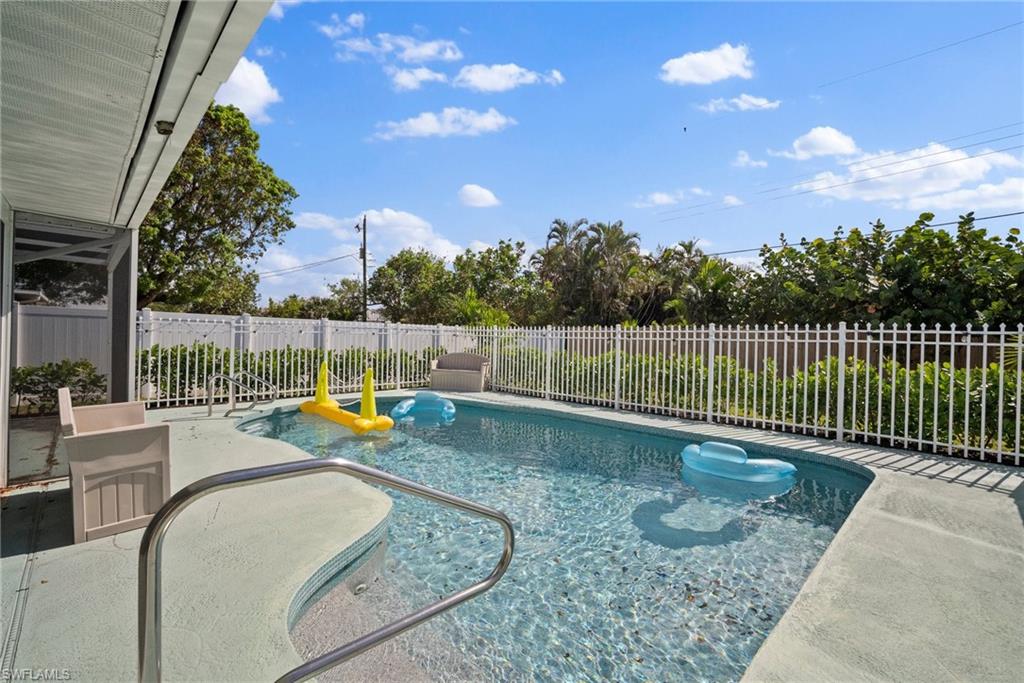 a view of a backyard with swimming pool and furniture