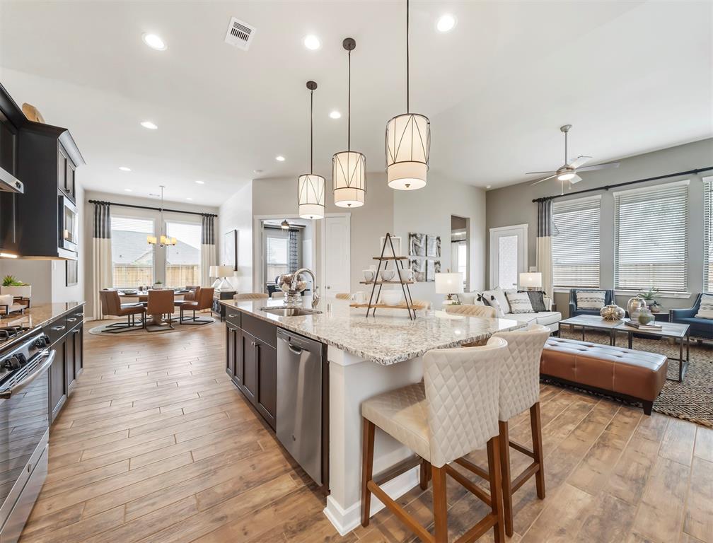 a large kitchen with lots of counter space a sink appliances and living room view