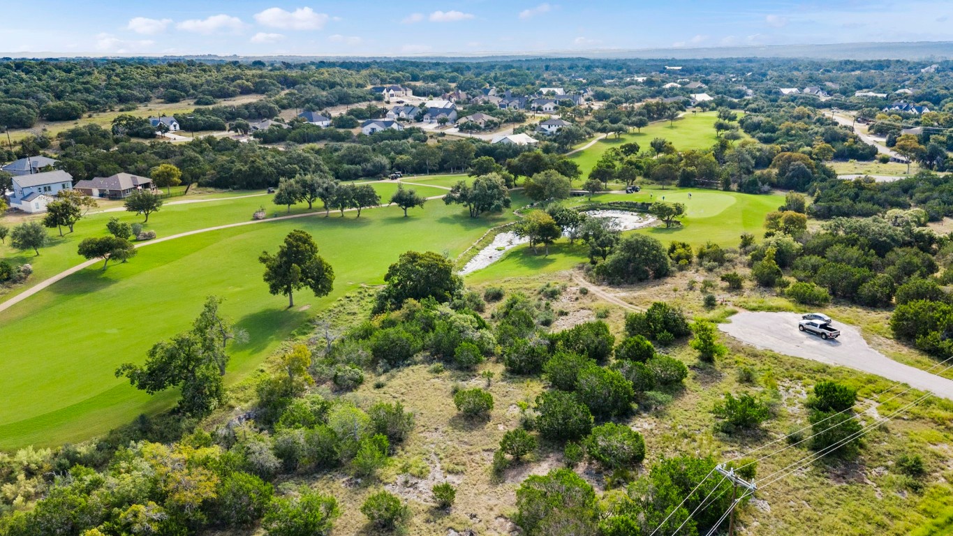 an aerial view of residential houses with outdoor space and trees