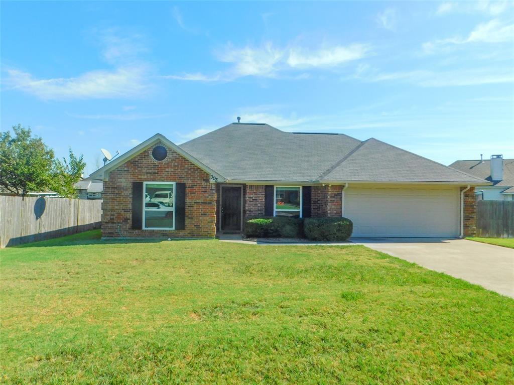 a front view of house with yard and trees in the background