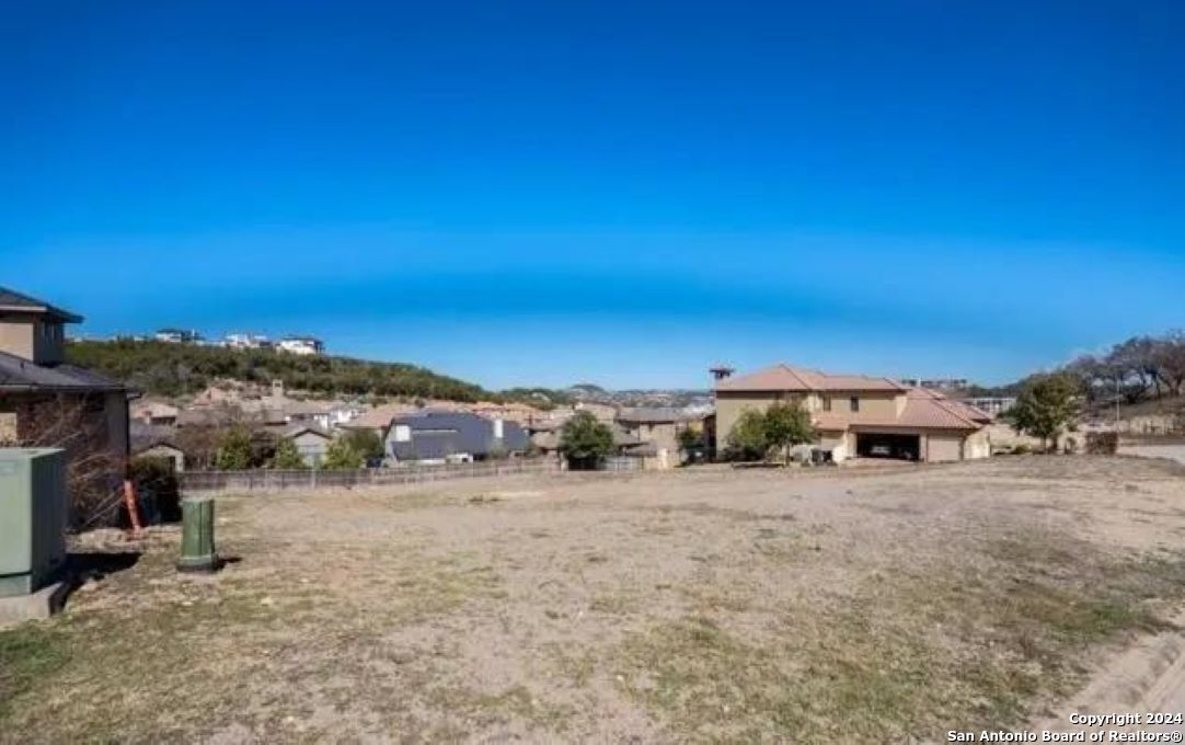 a view of a dry yard with trees