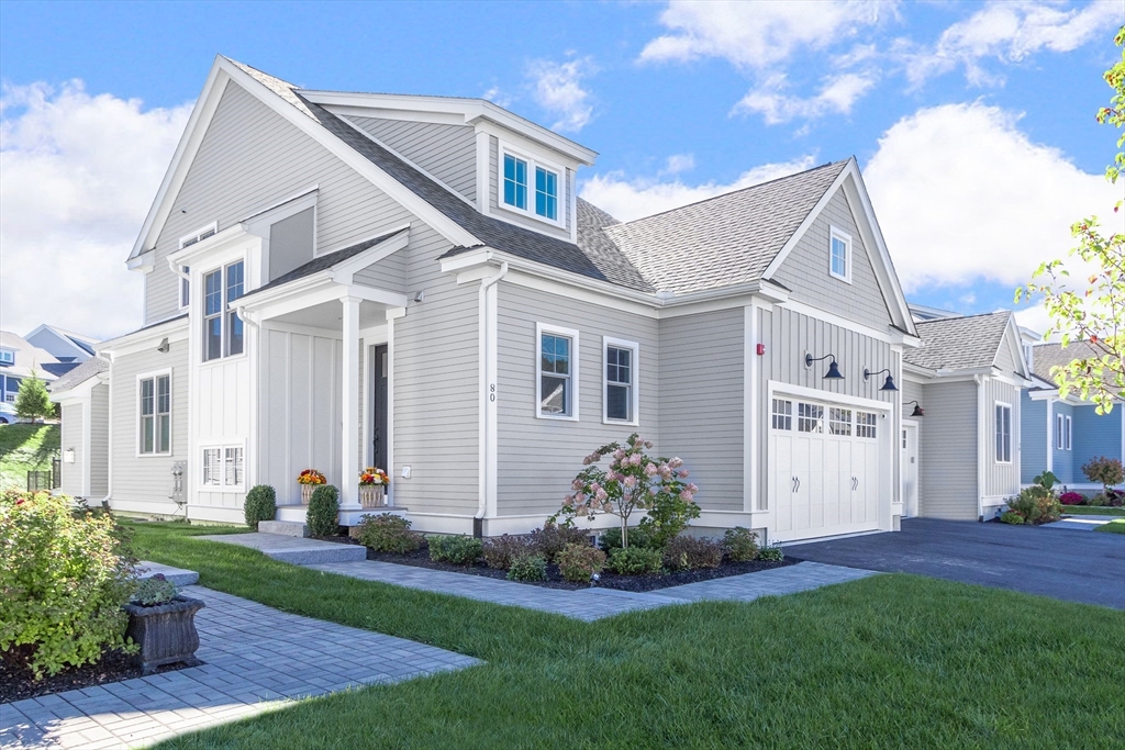 a front view of a house with a garden and plants