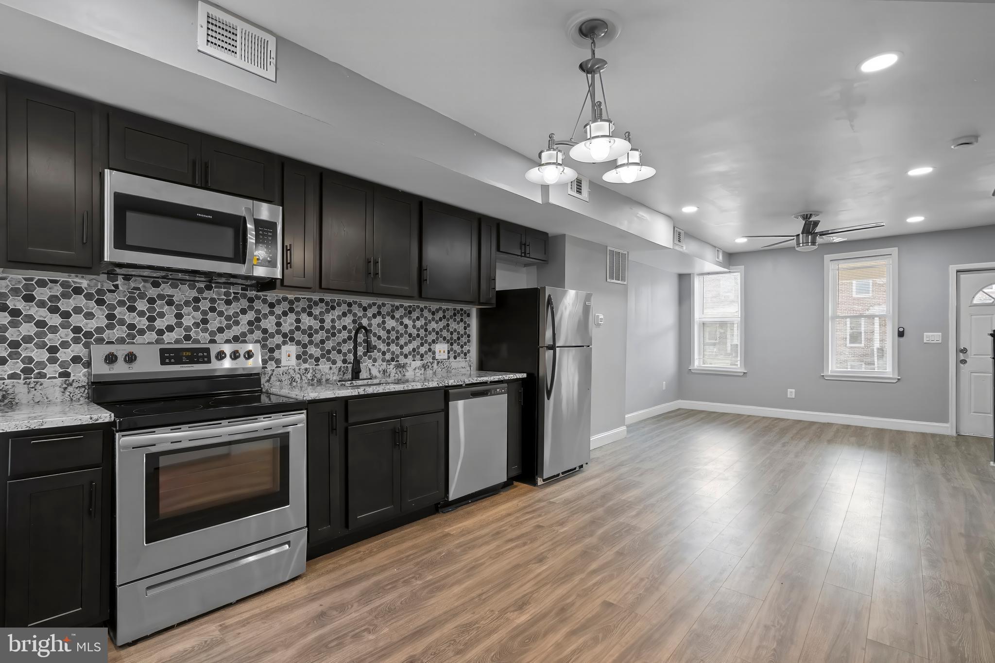 a kitchen with stainless steel appliances granite countertop wooden floors and granite counter tops