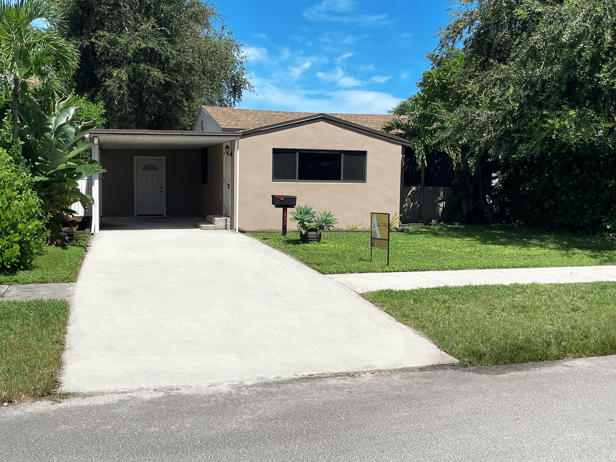 a front view of a house with yard and green space