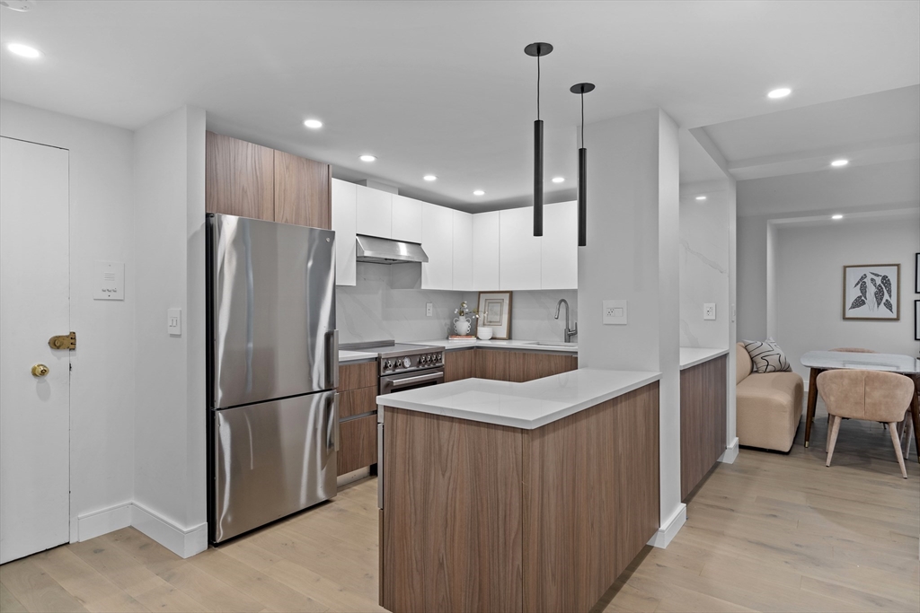 a kitchen with stainless steel appliances granite countertop a refrigerator a sink and a refrigerator