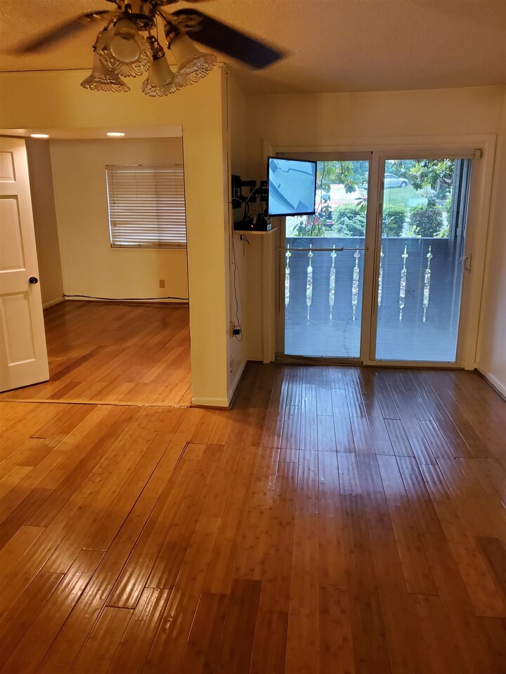 a view of a room with wooden floor and a window