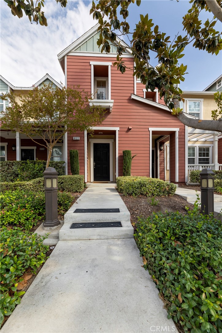 a front view of a house with a yard and potted plants