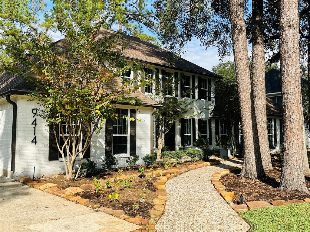 a front view of a house with a tree in front