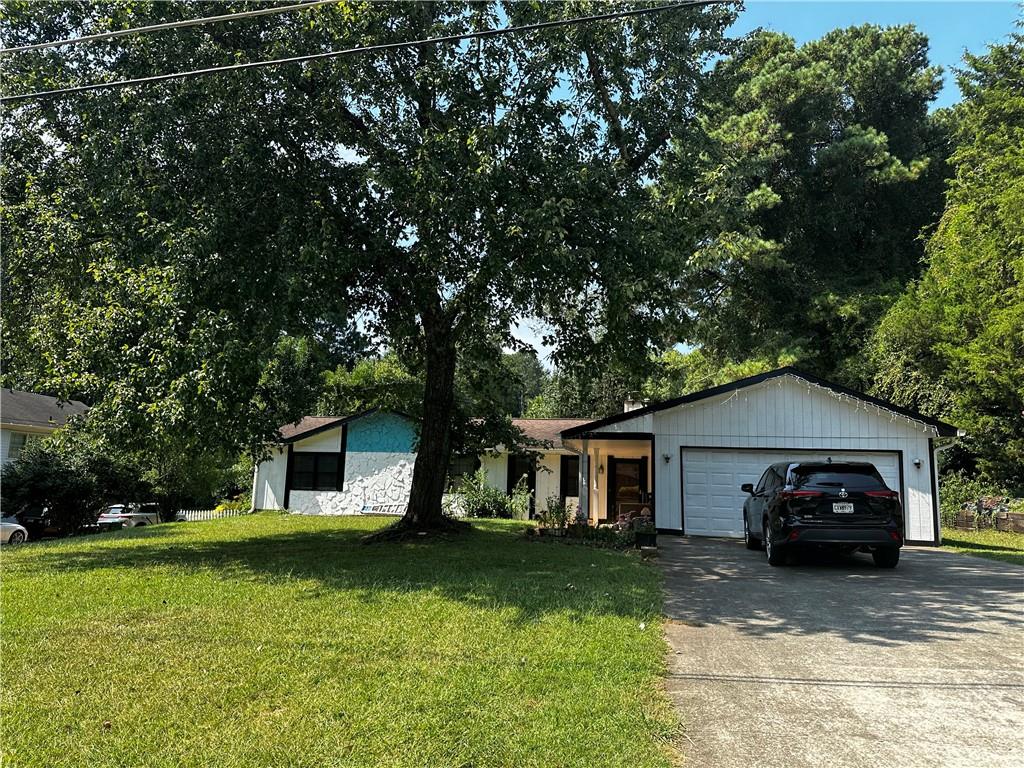 a front view of a house with a garden and trees